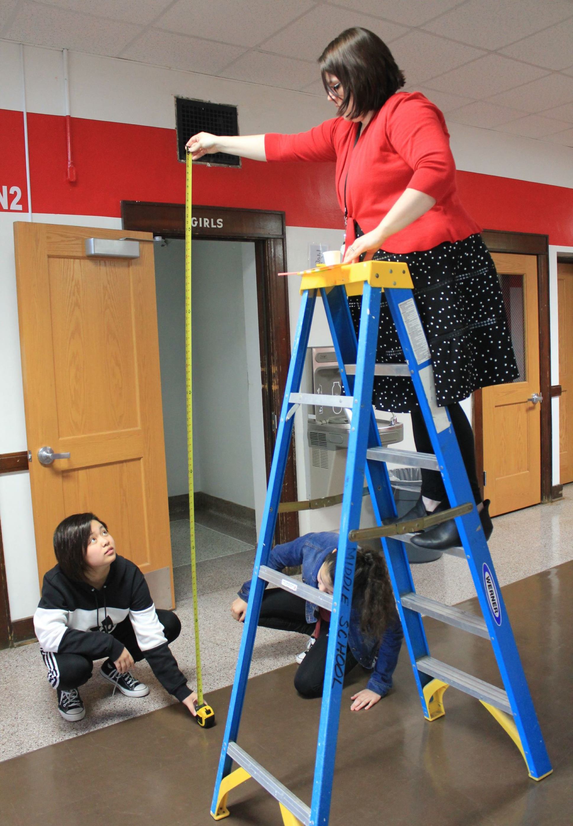 Teacher holding a tape measure. 